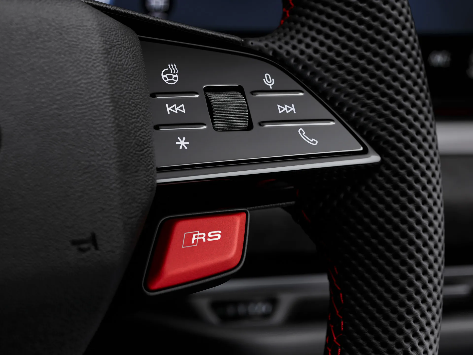 Audi RS steering wheel with red RS mode button and control switches close up